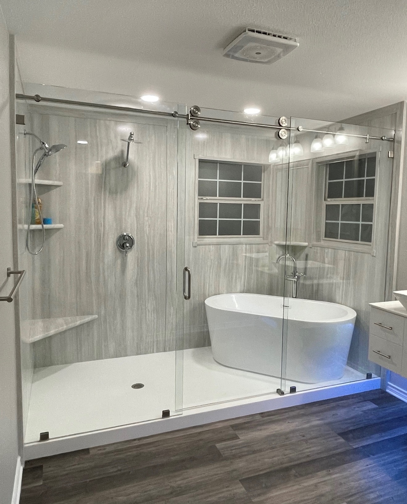 modern bath with a tub, shower, and wall fixtures for shower storage space.